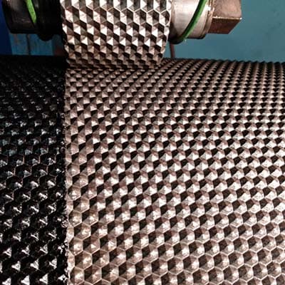 Close-up of embossing roller surface showing hexagonal emboss pattern